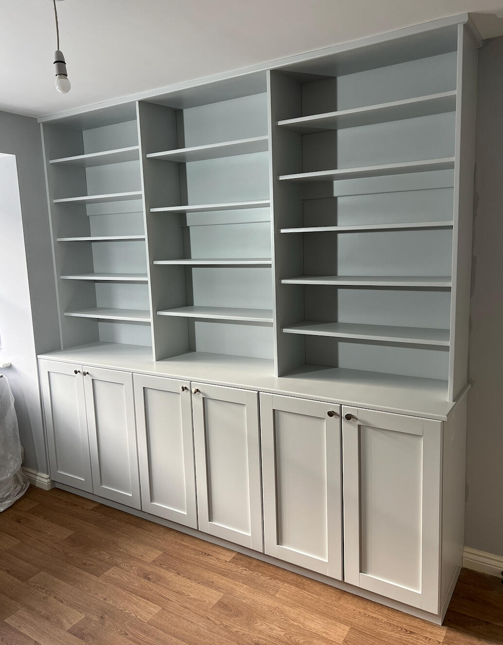 White sprayed fitted shelving and storage cabinets after specialist furniture spraying in Telford with a smooth factory-quality finish.