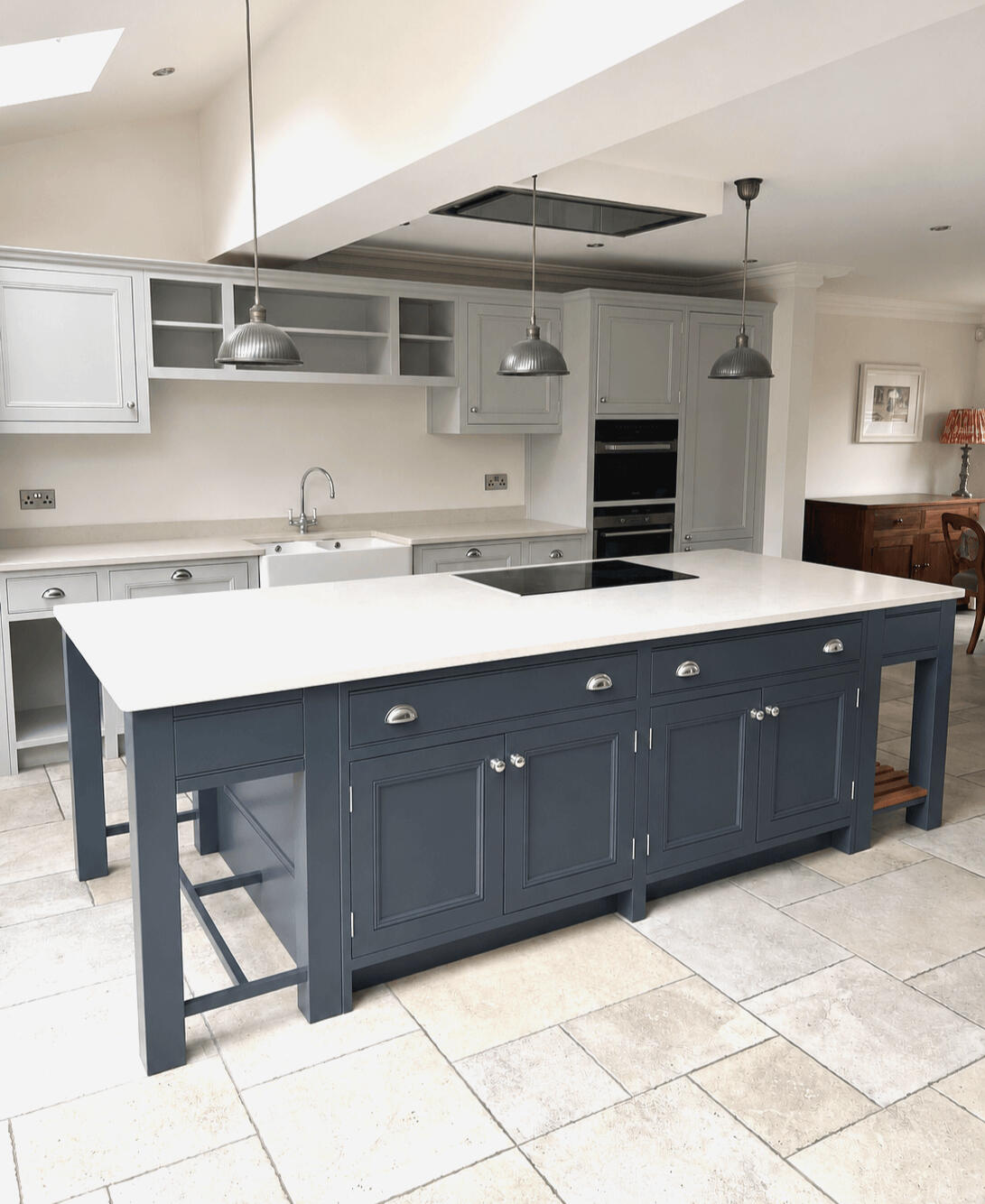 Two-tone shaker kitchen after professional hand painting, featuring light grey cabinets and a dark blue island finished by Wilkinson Specialist Sprays in Wombourne.